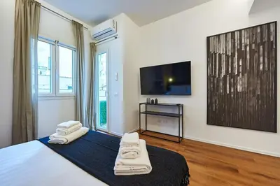 a bedroom with a bed with a tv and towels at Art Suite San Giovanni in Rome