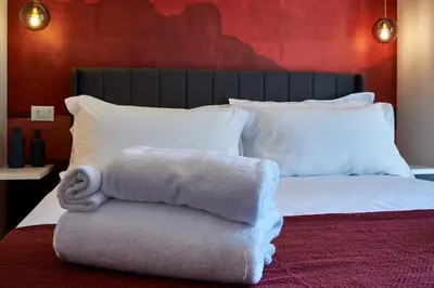 a bed with a pile of towels on it at Art Suite San Giovanni in Rome