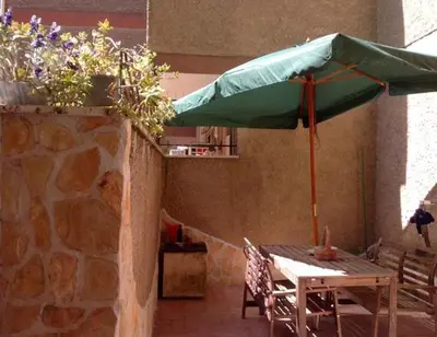 a table with a green umbrella on a patio at St Peter Vatican Lovely Apartment & Patio, Rome in Rome