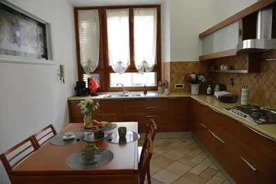 a kitchen with a table and chairs and a kitchen with a sink at Casa Iulia - Raffinata dimora nel cuore di Roma in Rome