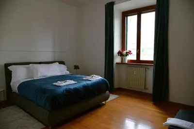a bedroom with a bed with blue sheets and a window at Casa Iulia - Raffinata dimora nel cuore di Roma in Rome