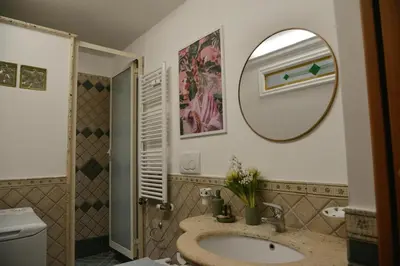 a bathroom with a sink and a shower with a mirror at Casa Iulia - Raffinata dimora nel cuore di Roma in Rome