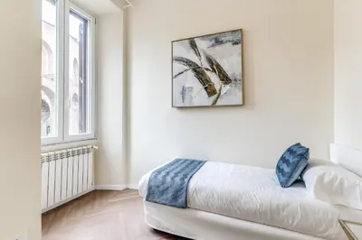 a white room with a bed and a picture on the wall at 3 minutes walk from Termini Station With Temple View in Rome