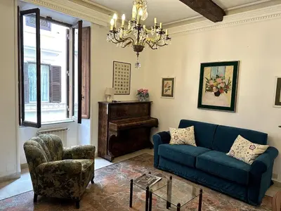 a living room with a couch and a chair and a chandelier at Borgo Pio Vatican in Rome