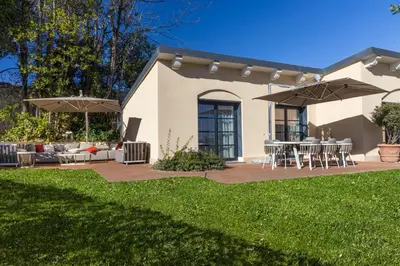 a house with a patio with tables and umbrellas at Exclusive Home with pool and iconic View on Saint Peter in Rome