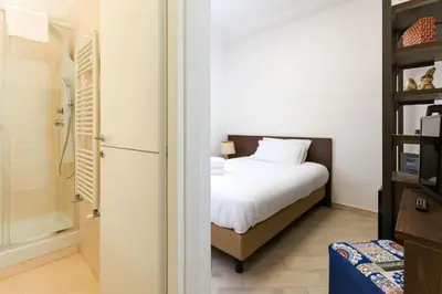 a bedroom with a white bed and a shower at Villa Aurora Rooms in Rome