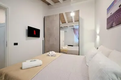 a bedroom with a large white bed with towels on it at 5 Cozy Pigneto Apt, Wifi & AC in Rome