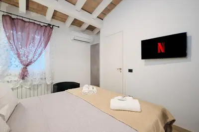 a bedroom with a bed with a tv on the wall at 5 Cozy Pigneto Apt, Wifi & AC in Rome