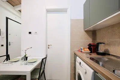 a small kitchen with a table and a sink at 5 Cozy Pigneto Apt, Wifi & AC in Rome