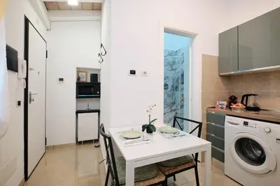 a kitchen with a white table and a washing machine at 5 Cozy Pigneto Apt, Wifi & AC in Rome