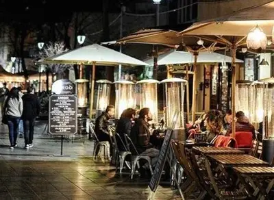 a group of people sitting outside a restaurant at night at A Casa di Mario al Pigneto in Rome
