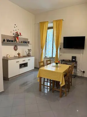 a living room with a dining table and a television at A Casa di Mario al Pigneto in Rome