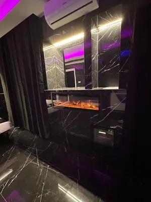 a fireplace in a room with black marble at Gladiatrice Suite in Rome