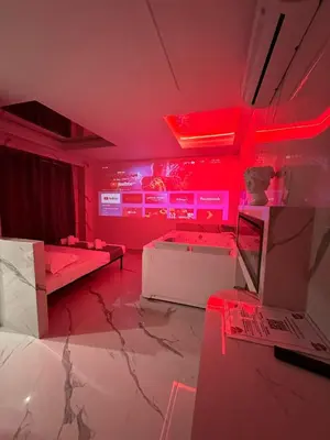 a room with red lights and a room with a bed and a table at Gladiatrice Suite in Rome