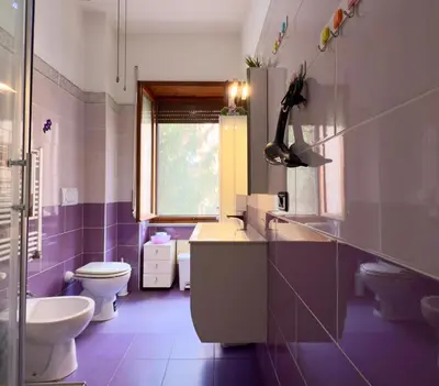 a purple bathroom with a toilet and a sink at Mancinelli Rome Apartment in Rome