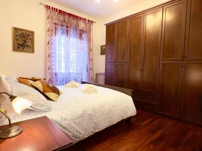 a bedroom with a bed and a large wooden cabinet at Mancinelli Rome Apartment in Rome