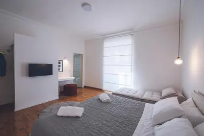 a white room with two beds and a flat screen tv at Habitat 42 Roman Stay in Rome
