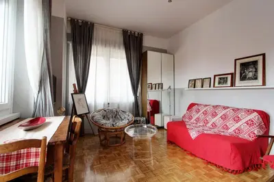 a living room with a red couch and a table at Le Note Di Angela in Rome