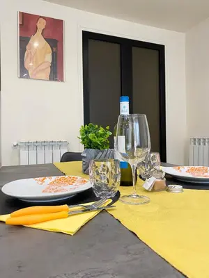 a table with a plate and wine glasses on it at PIRAMIDE Romantic Home in Rome
