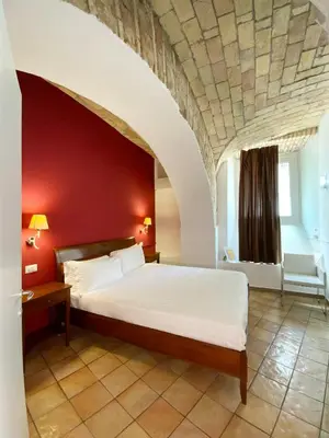 a bedroom with a large bed with a red wall at Roma Resort Colosseum in Rome