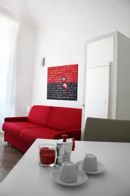 a living room with a red couch and a table at Roma Resort Colosseum in Rome