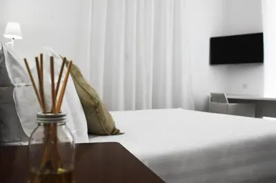 a bedroom with a bed and a table with a vase at Roma Resort Colosseum in Rome