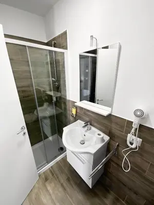 a white bathroom with a sink and a shower at Roma Resort Colosseum in Rome