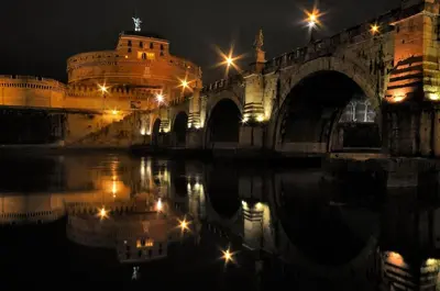 a bridge over a body of water at night at St Peter Vatican- Stylish Apt, Roma in Rome