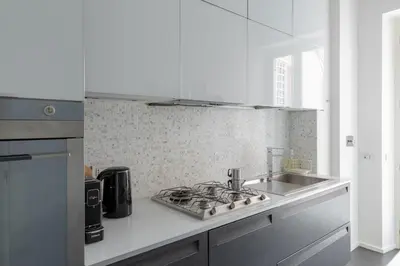 a white kitchen with a sink and a stove at HospitalityRome Vittorio Emanuele in Rome
