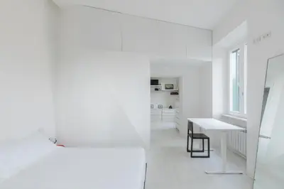 a white room with a bed and a desk at HospitalityRome Vittorio Emanuele in Rome