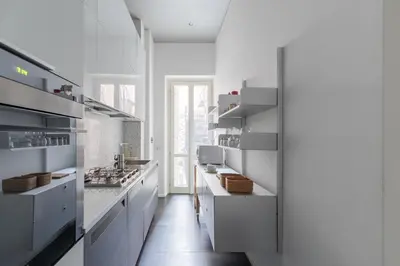 a white kitchen with white counters and white cabinets at HospitalityRome Vittorio Emanuele in Rome