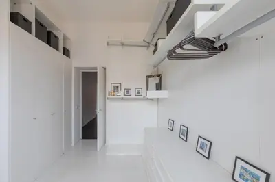 a hallway with white walls and pictures on the walls at HospitalityRome Vittorio Emanuele in Rome