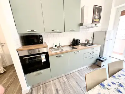 a kitchen with white cabinets and a sink and a microwave at Trastevere10 in Rome
