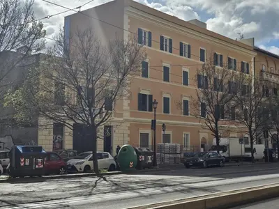 a large yellow building with cars parked in front of it at Colosseum Luxury suite 41 in Rome