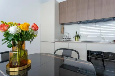 a vase of flowers on a glass table in a kitchen at Colosseum Luxury suite 41 in Rome