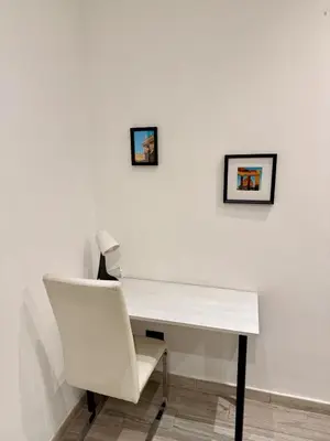 a white desk with a white chair and pictures on the wall at Appartamento stazione trastevere in Rome