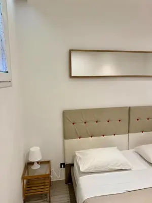 a bedroom with two beds and a table with a lamp at Appartamento stazione trastevere in Rome