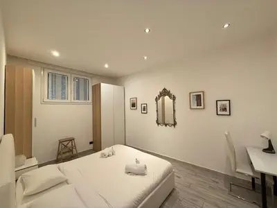 a bedroom with a bed and a desk and a mirror at Appartamento stazione trastevere in Rome
