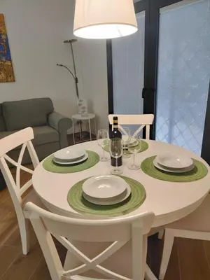 a white table with plates and wine glasses on it at Casa Beatrice, Trastevere in Rome