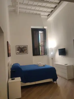 a bedroom with a blue bed and a window at Casa Beatrice, Trastevere in Rome