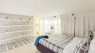 a bedroom with a bed with a plaid blanket at Trevi Fountain - Modern Suite in 17th-century Palazzo in Rome