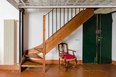 a wooden staircase in a room with a chair at Trevi Fountain - Modern Suite in 17th-century Palazzo in Rome