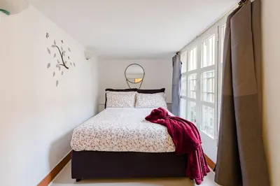 a bedroom with a bed and a large window at Trevi Fountain - Modern Suite in 17th-century Palazzo in Rome
