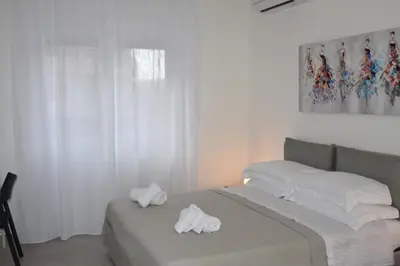a bedroom with two beds with white sheets and towels at SWEET RETREAT - Trastevere Station in Rome