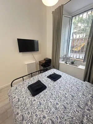 a bedroom with a bed with two black towels on it at Leonidas house 2 in Rome