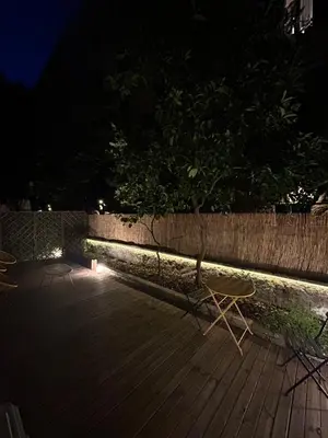 two chairs sitting on a wooden deck at night at Leonidas house 2 in Rome