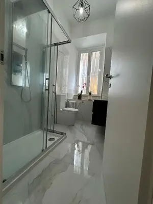 a white bathroom with a shower and a toilet at Leonidas house 2 in Rome