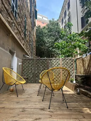 two yellow chairs sitting on a wooden deck at Leonidas house 2 in Rome