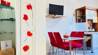 a room with red chairs and a table with a television at Casa Alice in Rome