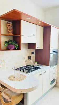 a kitchen with white cabinets and a stove top oven at Casa Alice in Rome
